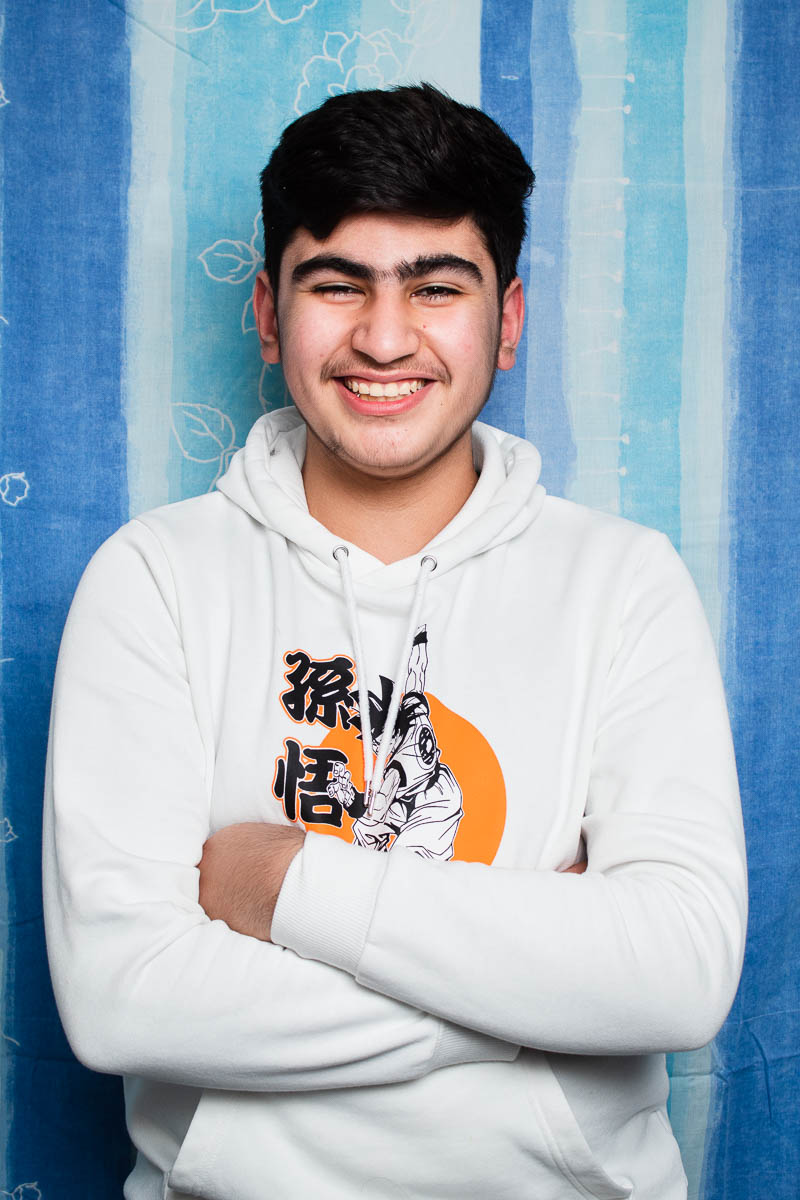 Portrait of Feras Halabi smiling to camera wearing a white jumper.