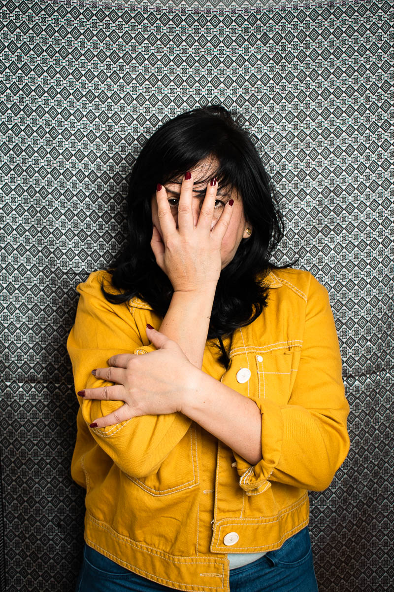 Portrait of Refugee Sophia covering her face with her right hand