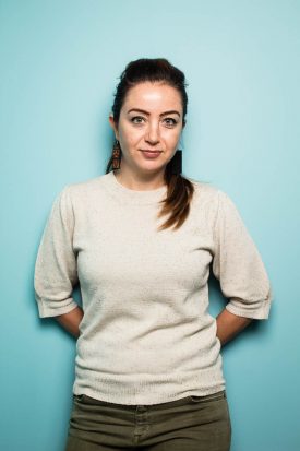 Portrait of refugee Zaina with her hands behind her back