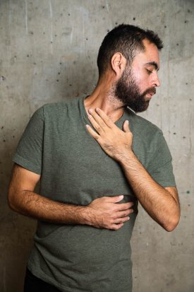 Portrait of refugee Mostafa with his arms hugging his body