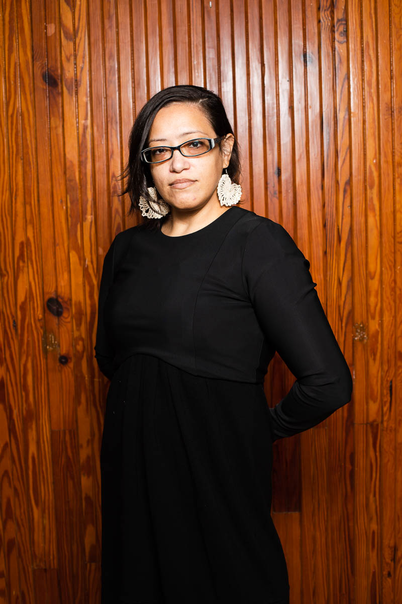 Portrait of refugee Araminta against a wooden background