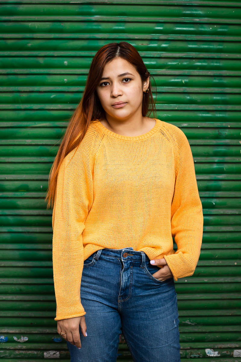 Portrait of refugee Valentina against a green background