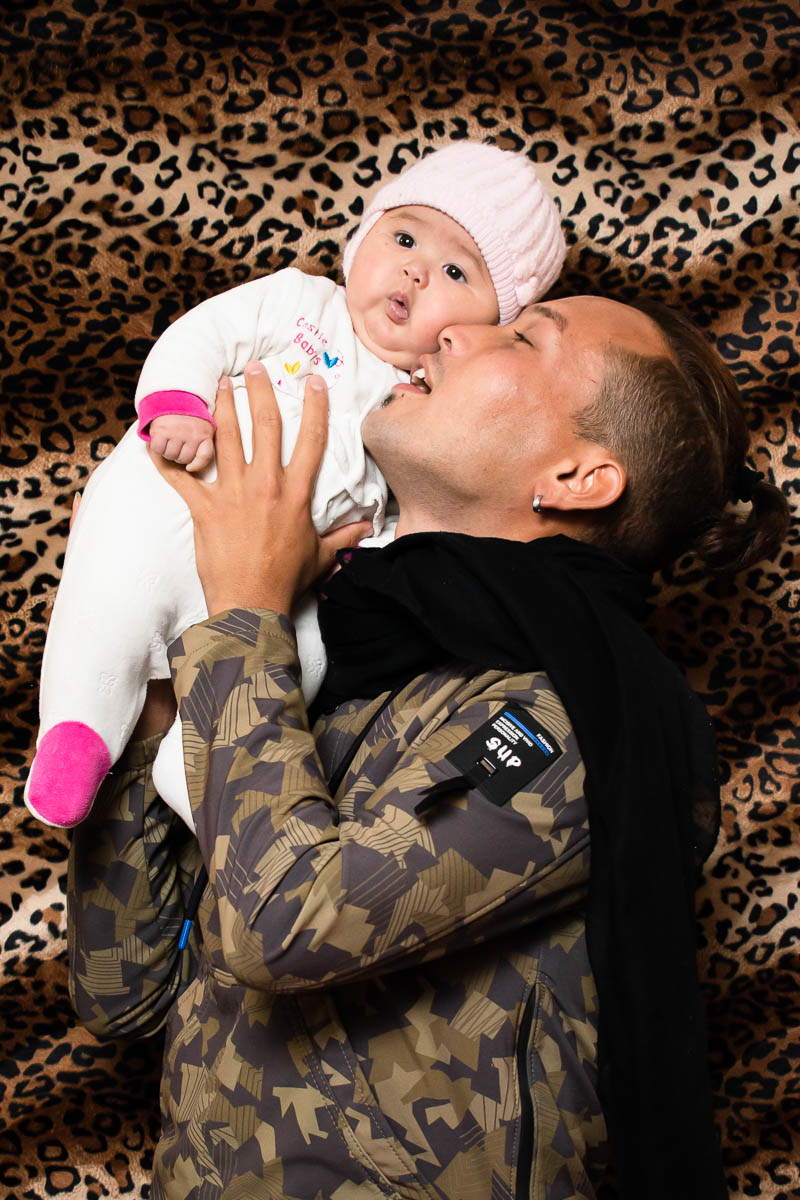Portrait of refugee Amir holding his daughter