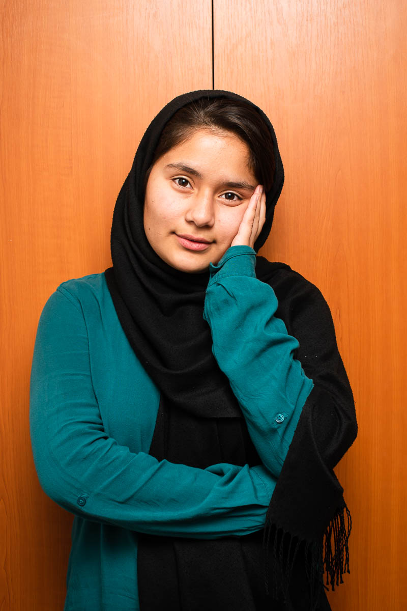 Portrait of refugee Mahdieh with her hand on her cheek