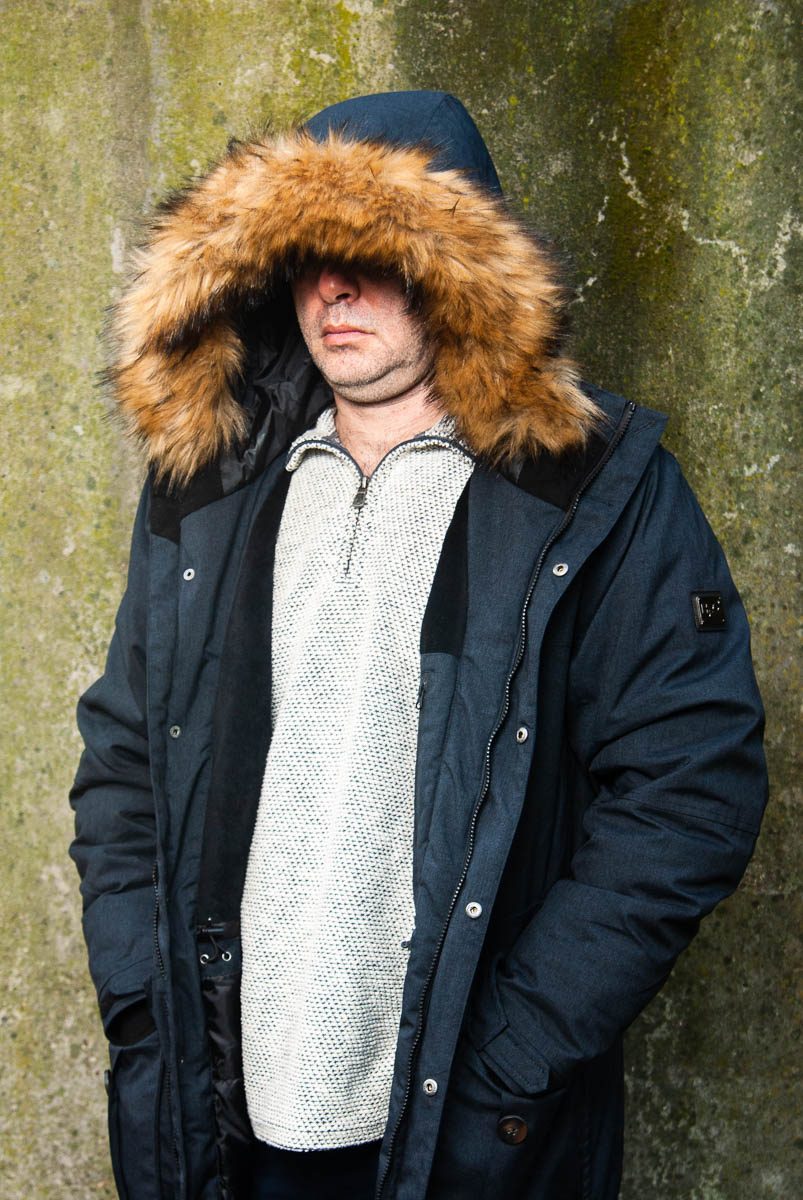Portrait of refugee Azarnoosh wearing a parka jacket and the hood hiding their face