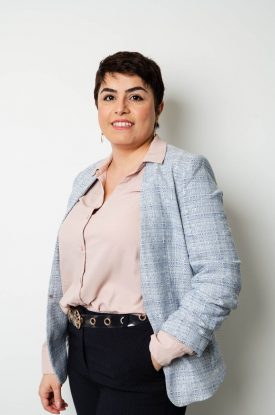 Portrait of refugee Leila with a pixie cut and her hand in her pocket