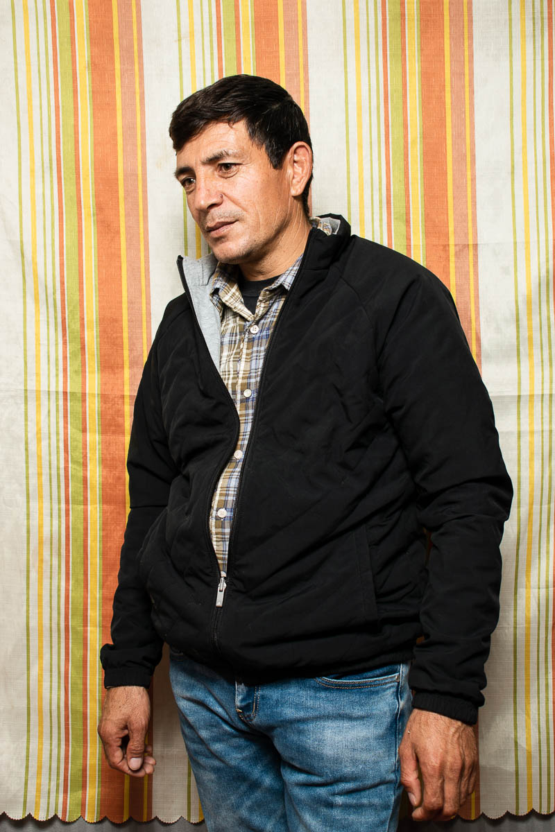 Portrait of refugee Seyed wearing a black jacket