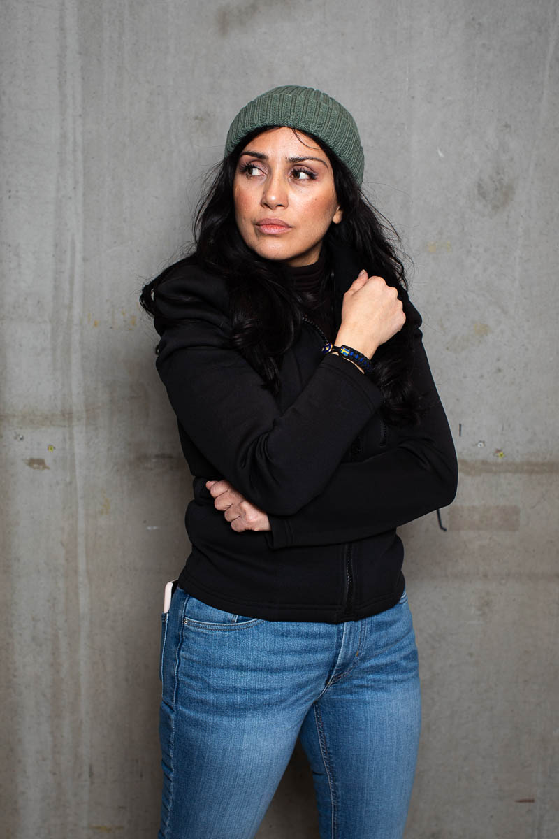 Portrait of refugee Sahar wearing a beanie, looking to her right