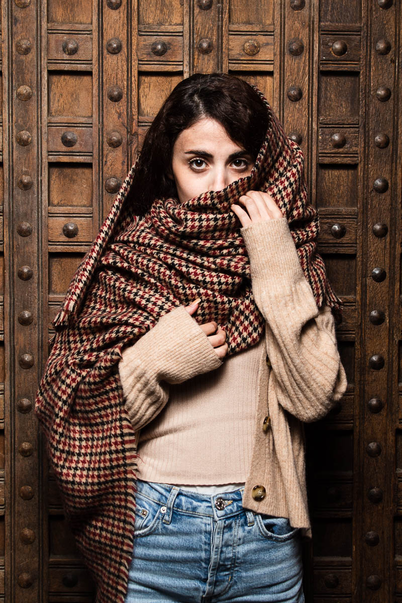 Portrait of refugee Alia with a woollen shawl wrapped around her covering her mouth and hair