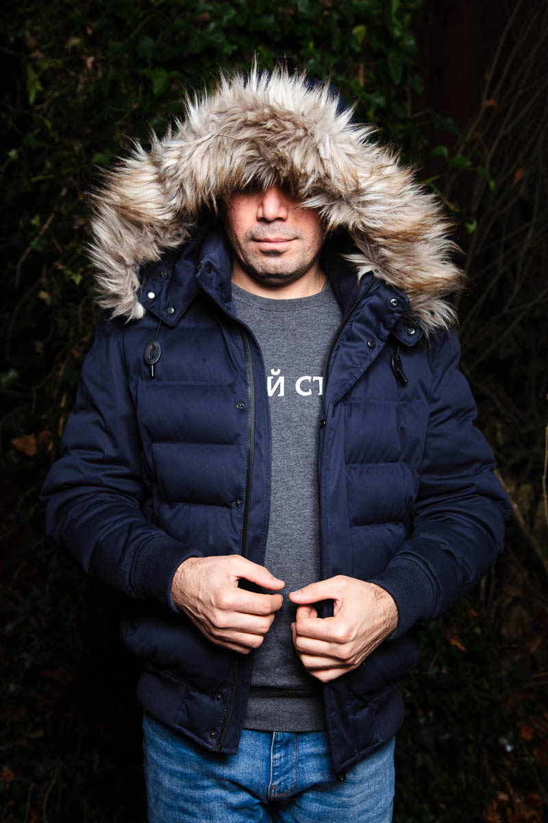 Portrait of refugee Ahmed wearing a Parka covering his forehead and eyes.