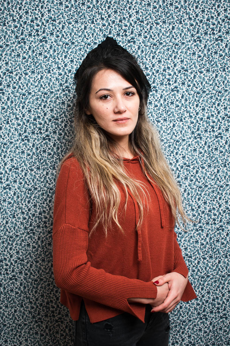 Portrait of refugee Tuğçe with her hands folded