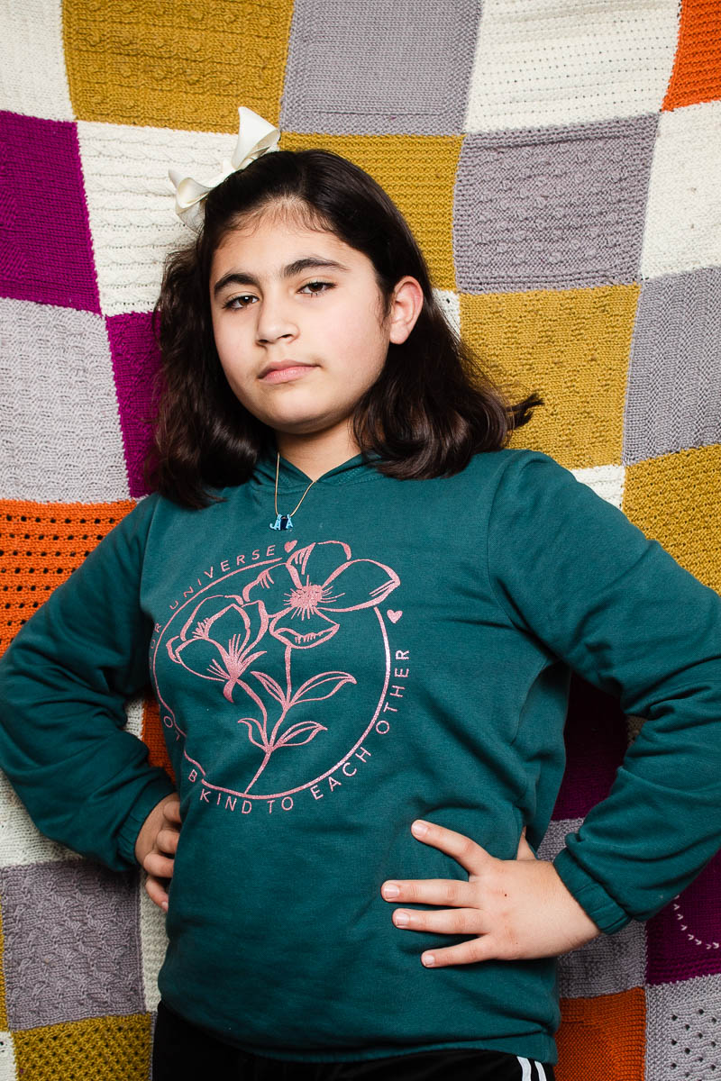 Portrait of child refugee Jana standing with her hands on her hips