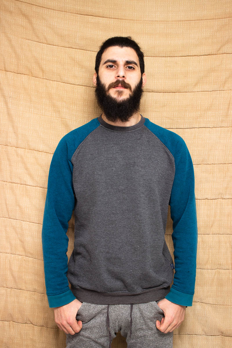 Portrait of refugee Majd standing with his hands in his pockets