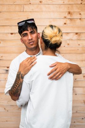 Portrait of refugee Masoud hugging a person with a hair bun