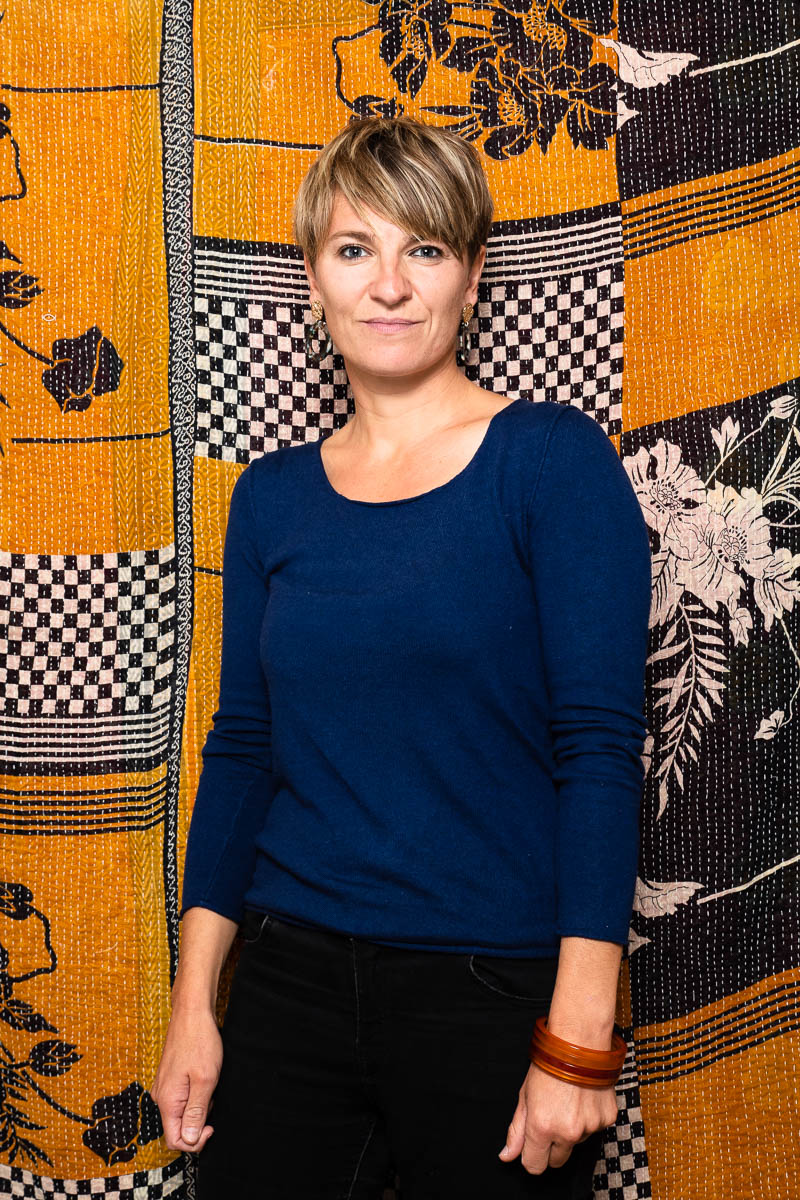 Portrait of refugee Sejla wearing glass bangles in her left hand with a pixie cut