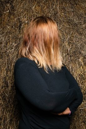 Portrait of refugee Maryam with her face turned and hidden to show the back of her hair