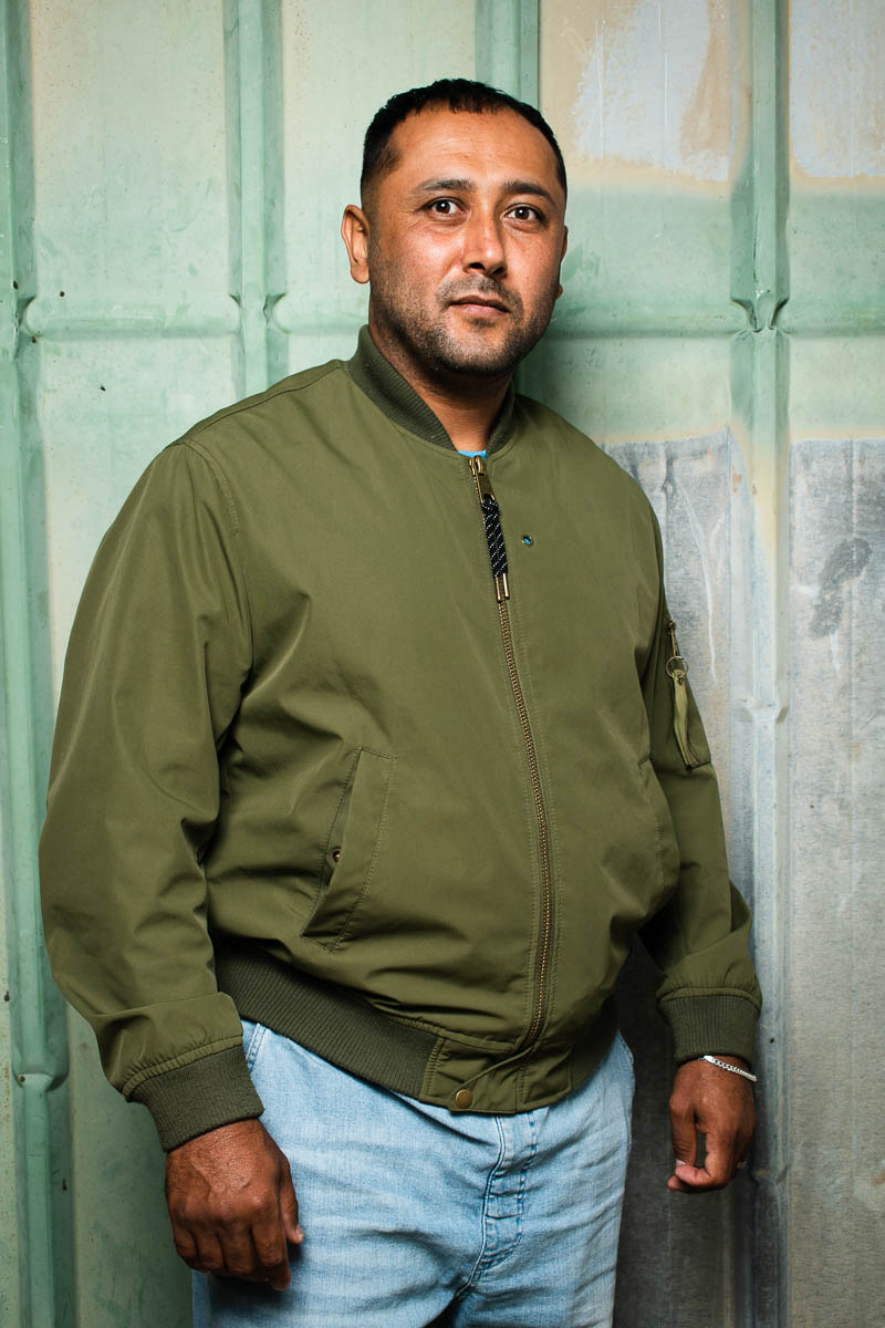 Portrait of refugee Nasir wearing a green jacket