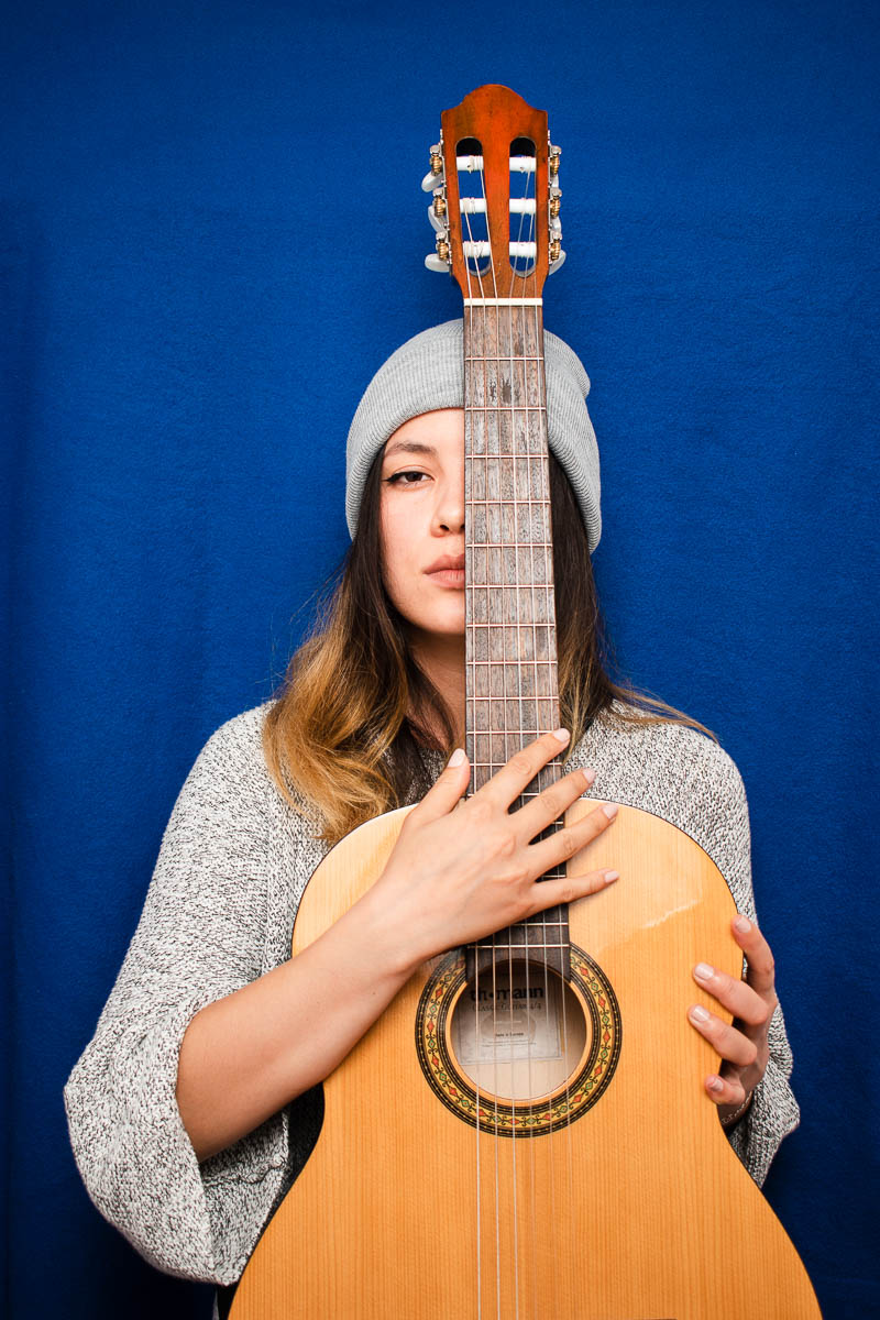 Portrait of refugee Elena holding a guitar