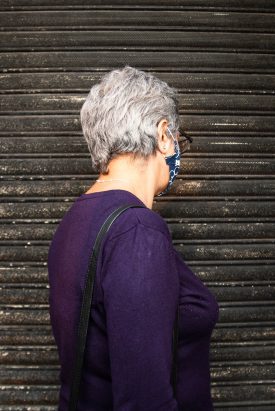 Portrait of refugee Azar wearing a purple top turned away from the camera