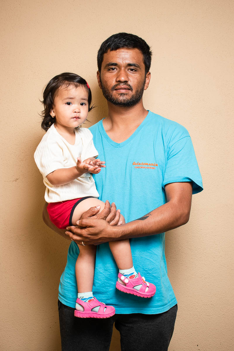 Portrait of refugee Habib holding his daughter in his arms