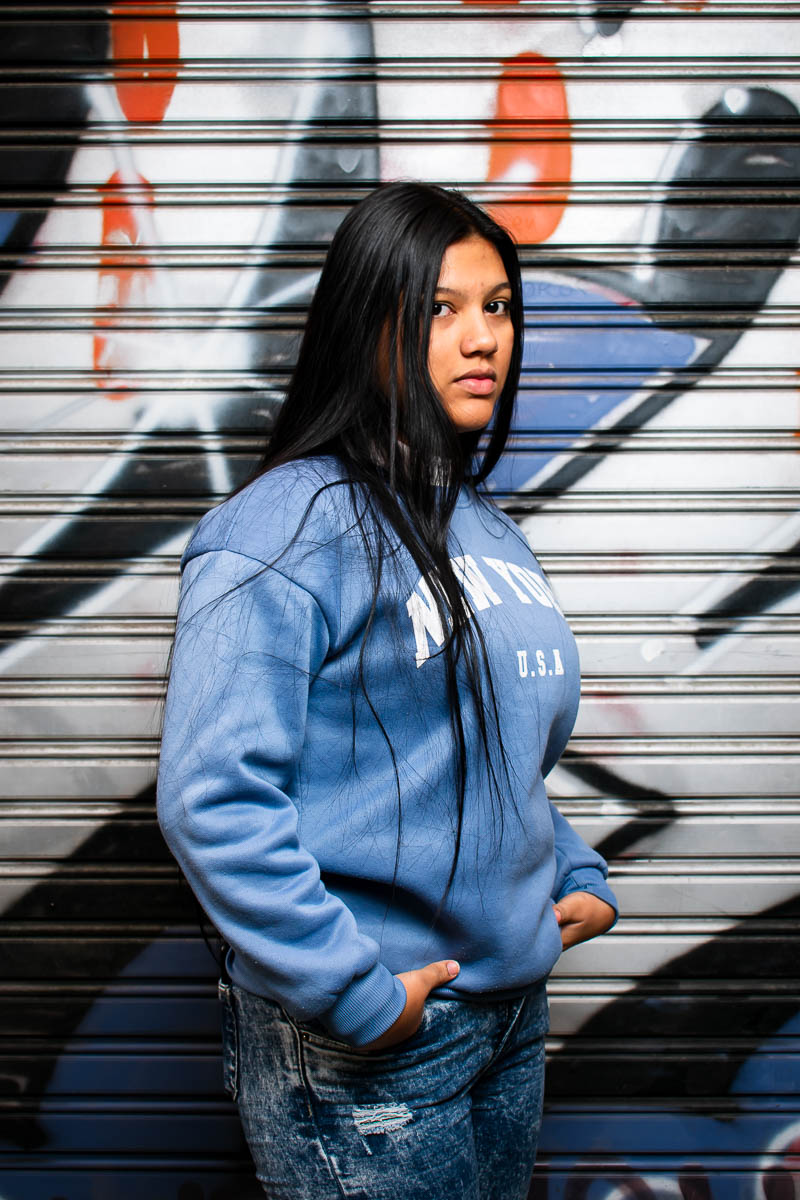 Portrait of Chabela,facing sideward in the camera. Long hait, hands in purse wearing a light blue jacket