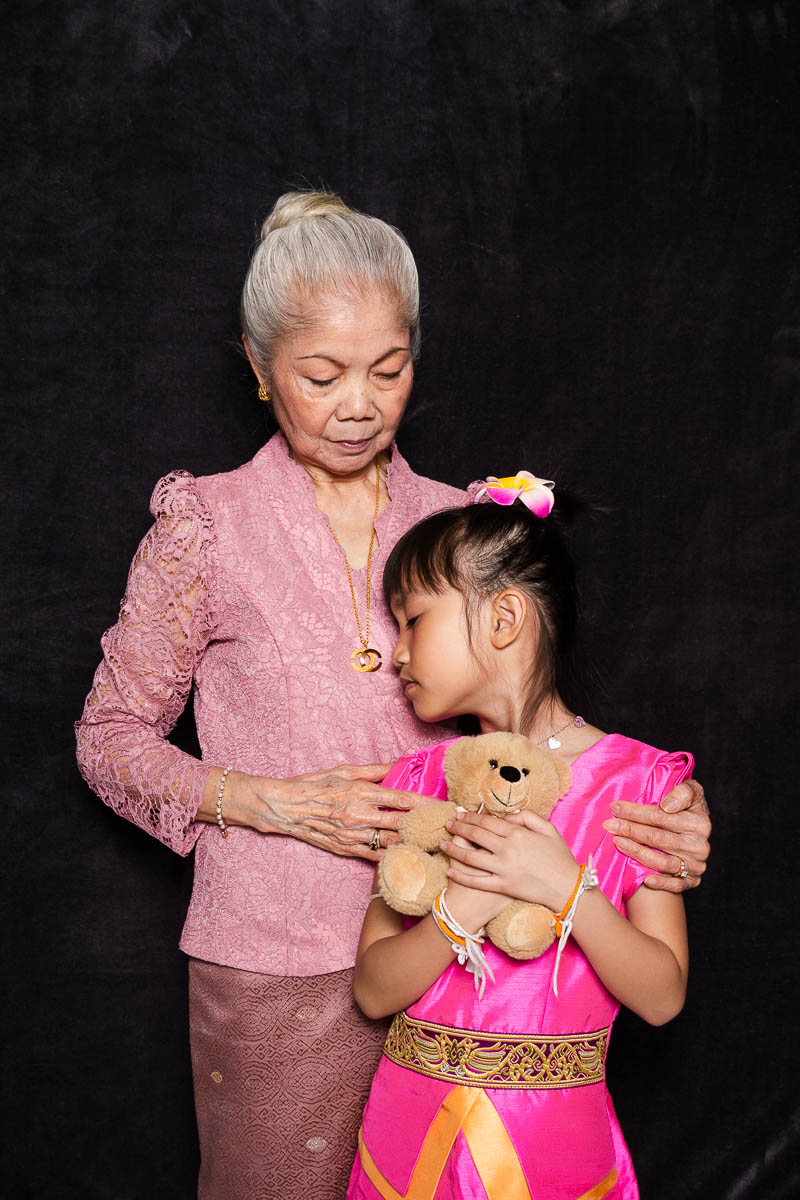 Portrait of Nhay, together with her daughter both wearing pink upper clothes and is holding each other