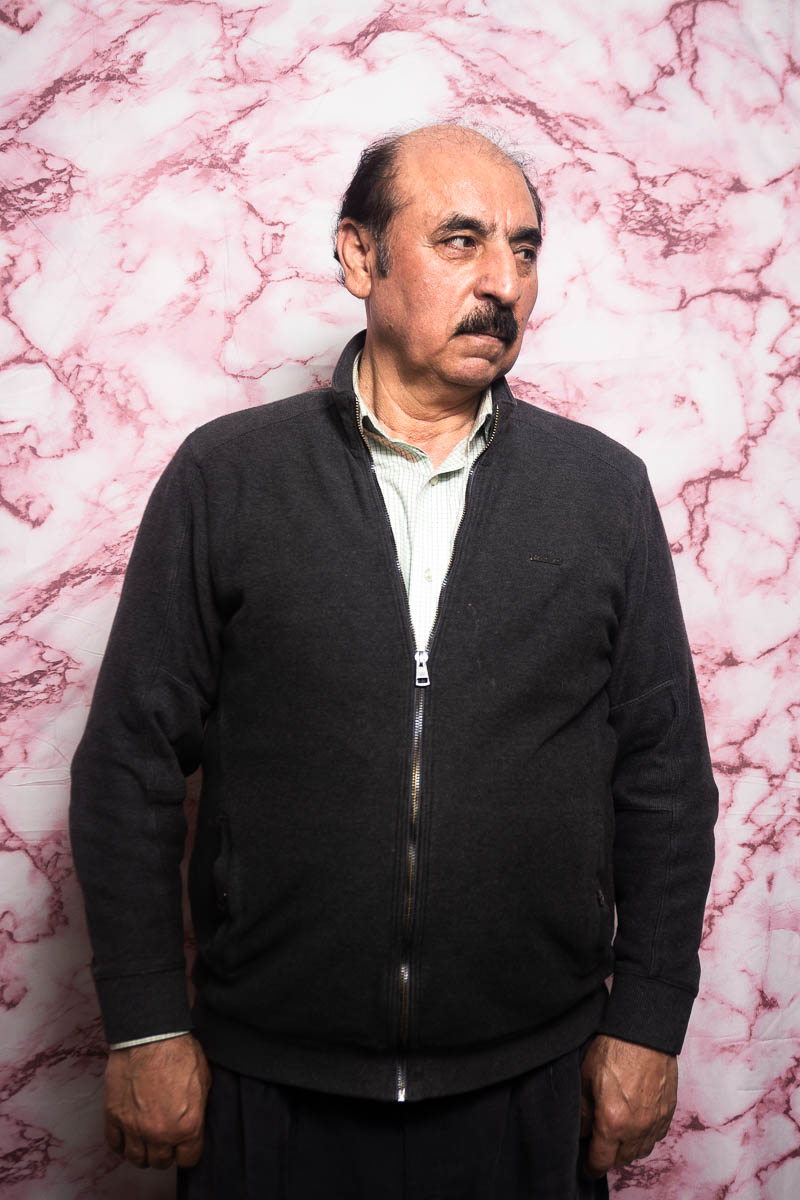 Portrait of Nazar, not facing directly to the camera and is wearing a black jacket and white underneath