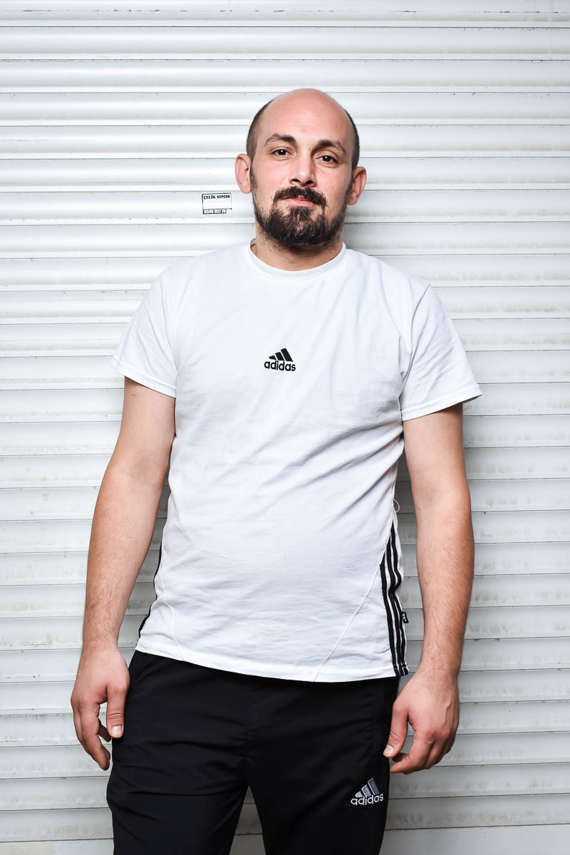 Portrait of Halit, facing neutral in the camera wearing a white shirt .