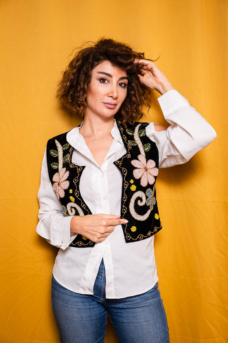 Portrait of Alaa, facing the camera wearing white sleeves, a printed black suit and pants.