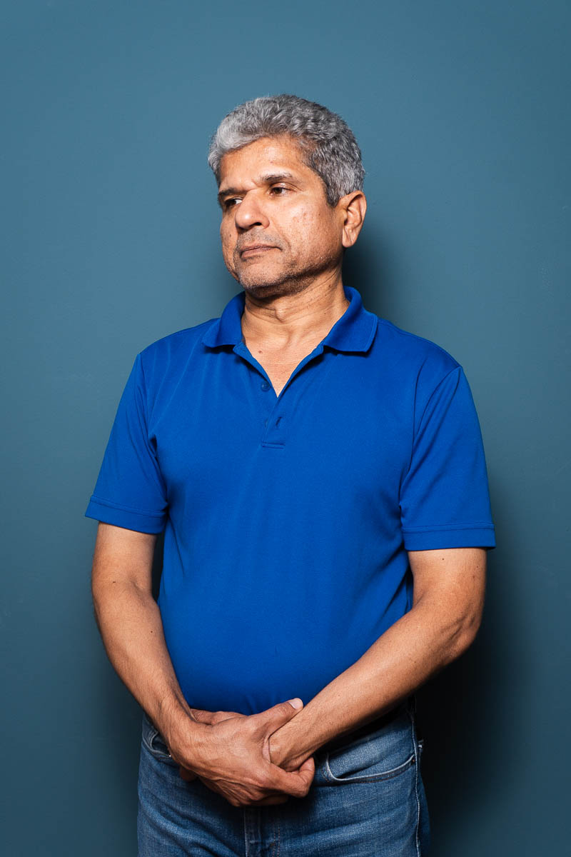 Portrait of Mehran, wearing blue polo and denim pants.