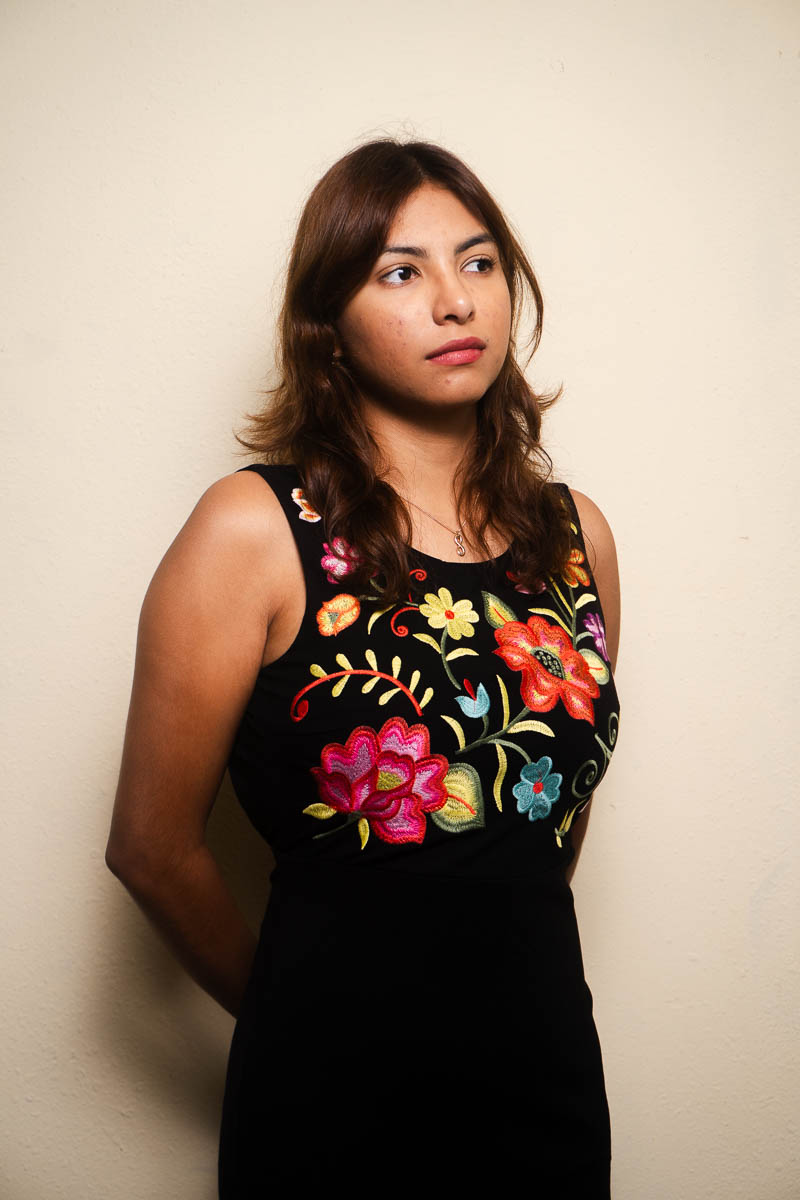 Portraif of Stefany, wearing a floral black dress and facing sideways.