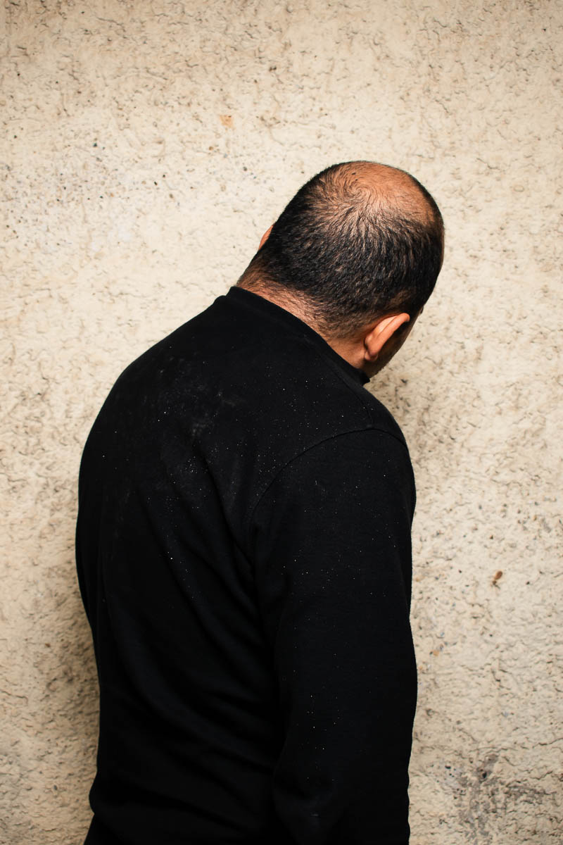 Portrait of Ali, not facing in the camera and is wearing black.