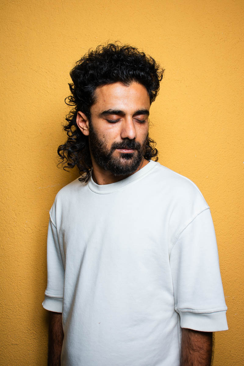 Portrait of Givara, facing sideways wearing a white shirt.