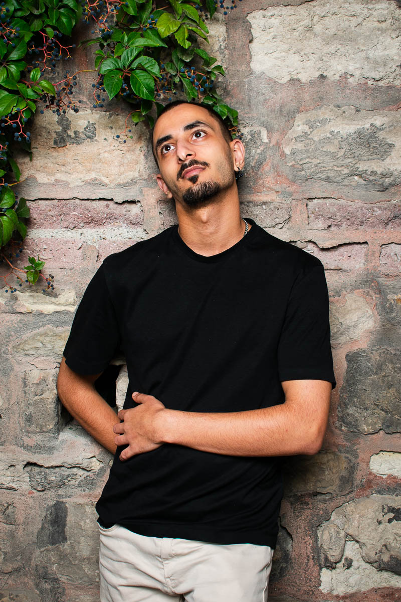 Portait of Abdulrahman, staring upward wearing a black shirt.