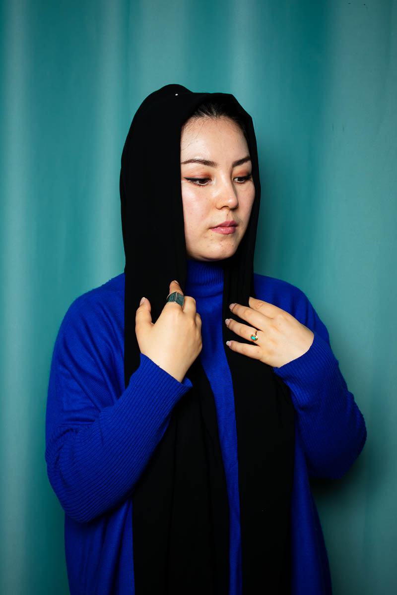 Portrait of Abida, has long black hair wearing a blue jacket.