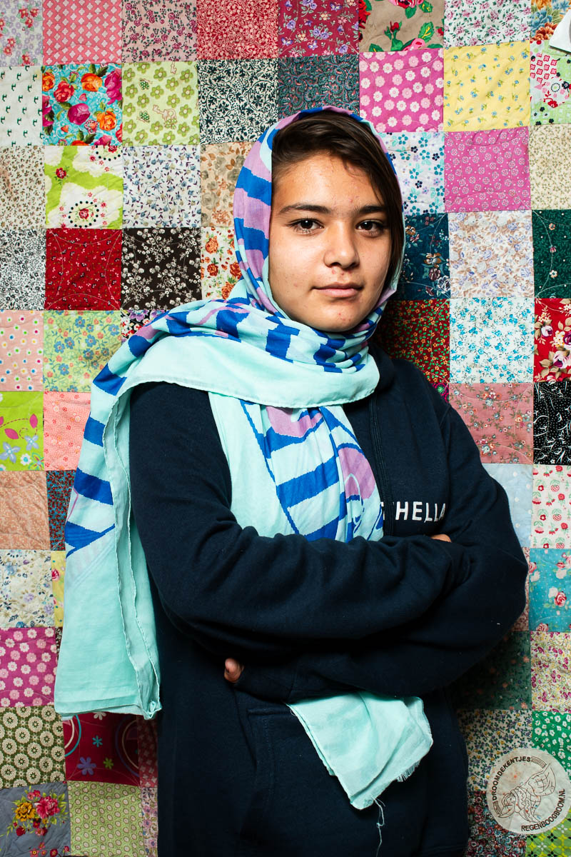 Portrait of Neda, smiling at the camera, covering her head with a cloth.