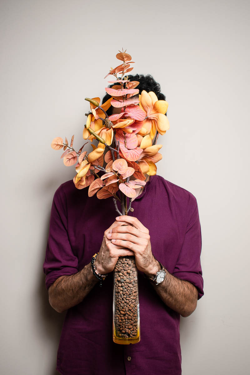 Portrait of Zaki wearing a purple shirt covering his face.