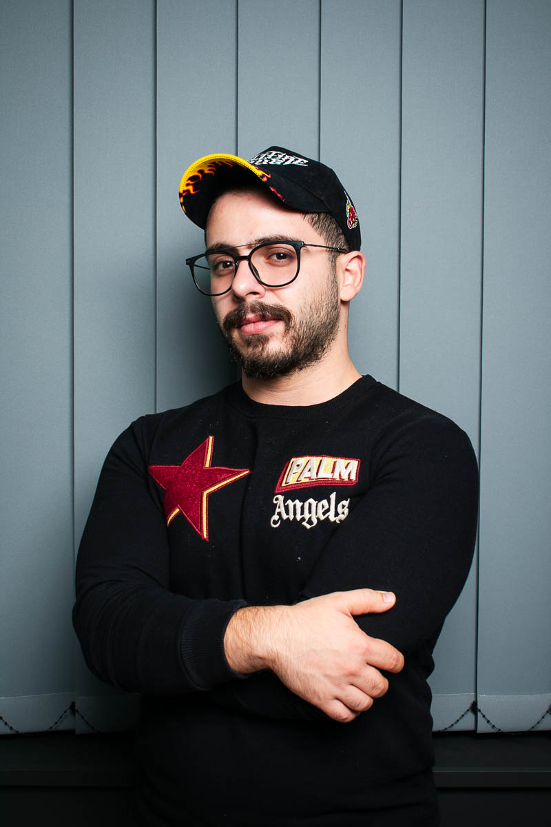 Portrait of Bashar, facing the camera wearing an eyeglasses and a cap.