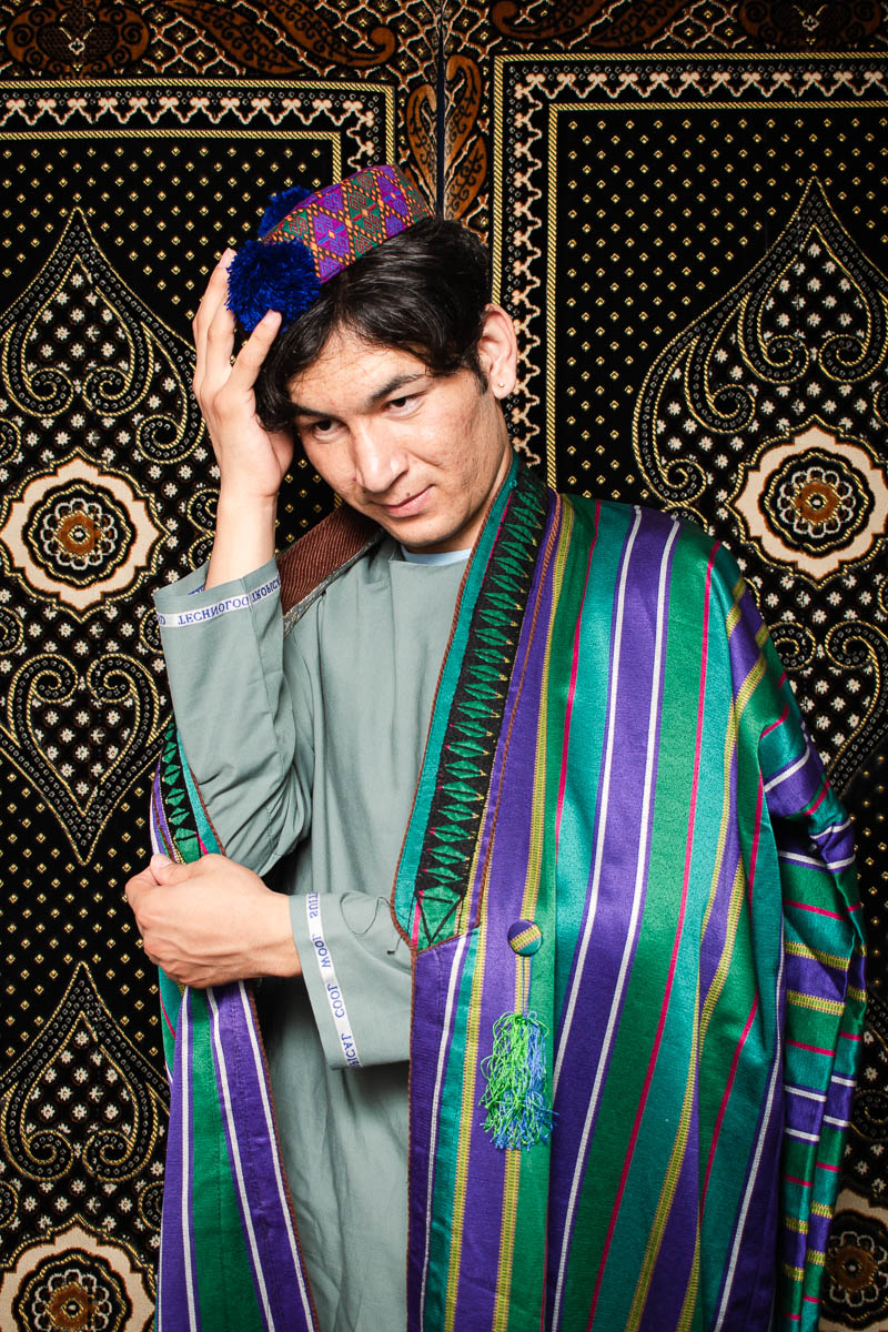 Portrait of Ali, wearing a robe and holding his cap