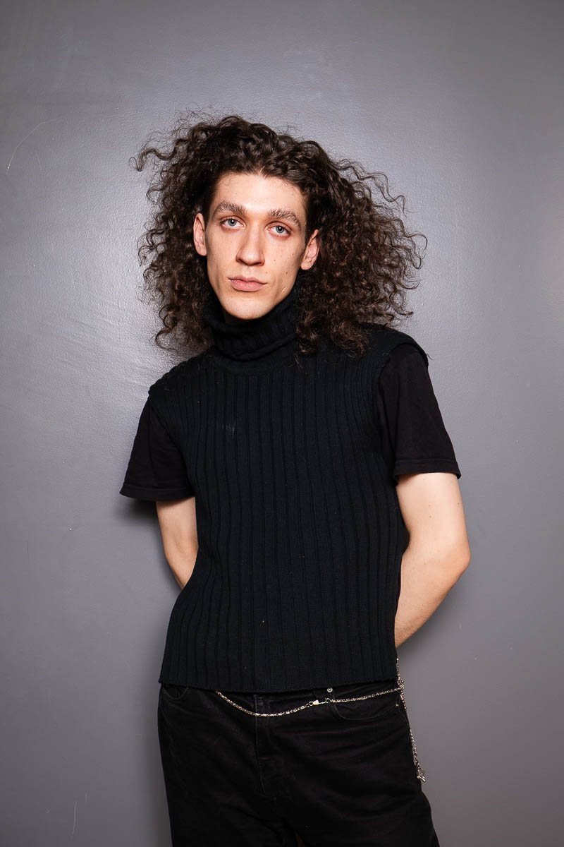 Portrait of Arty, looking intently at the camera and is wearing a black shirt.