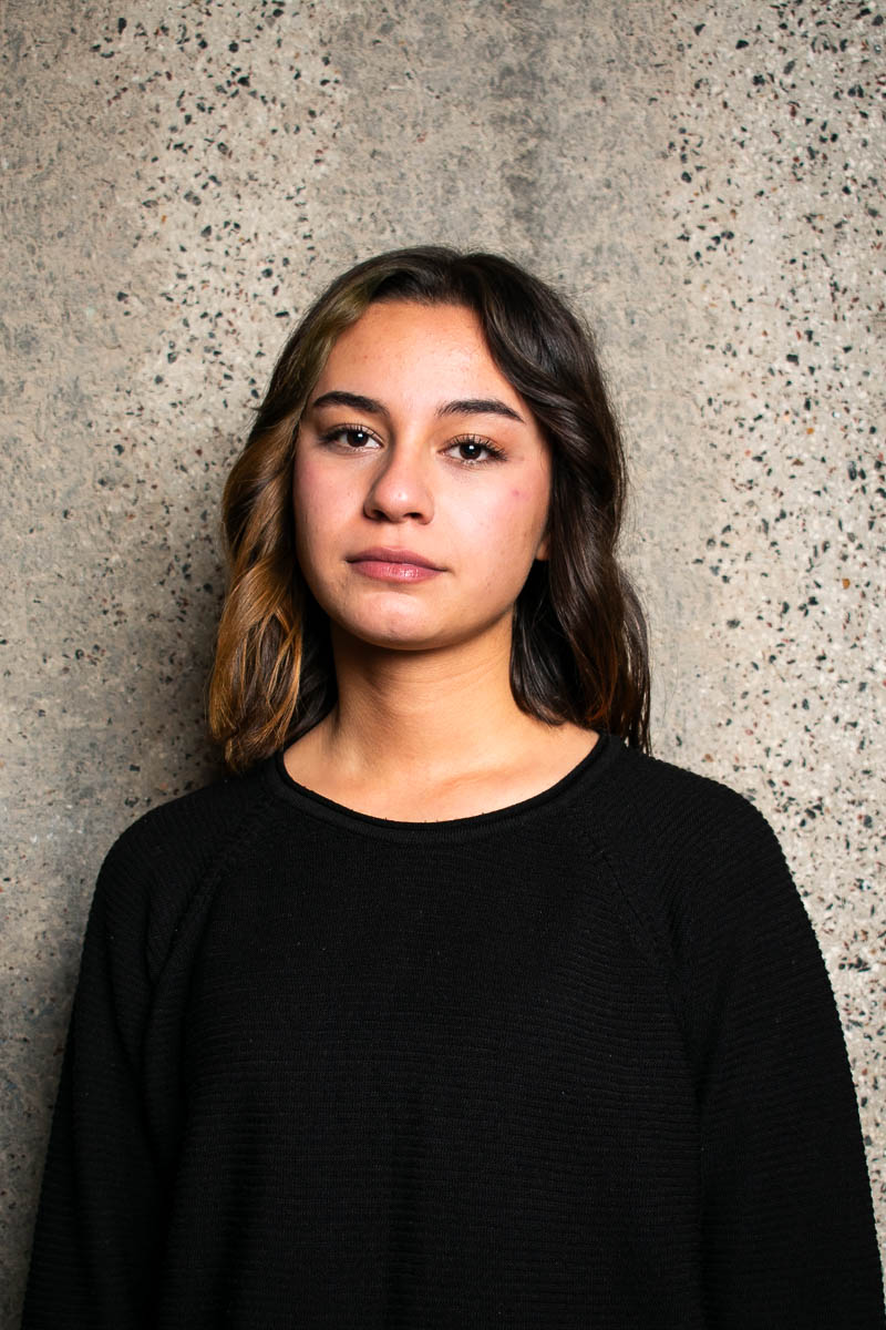 Portrait of Lilav, facing neutral in the camera and is wearing black long sleeves.