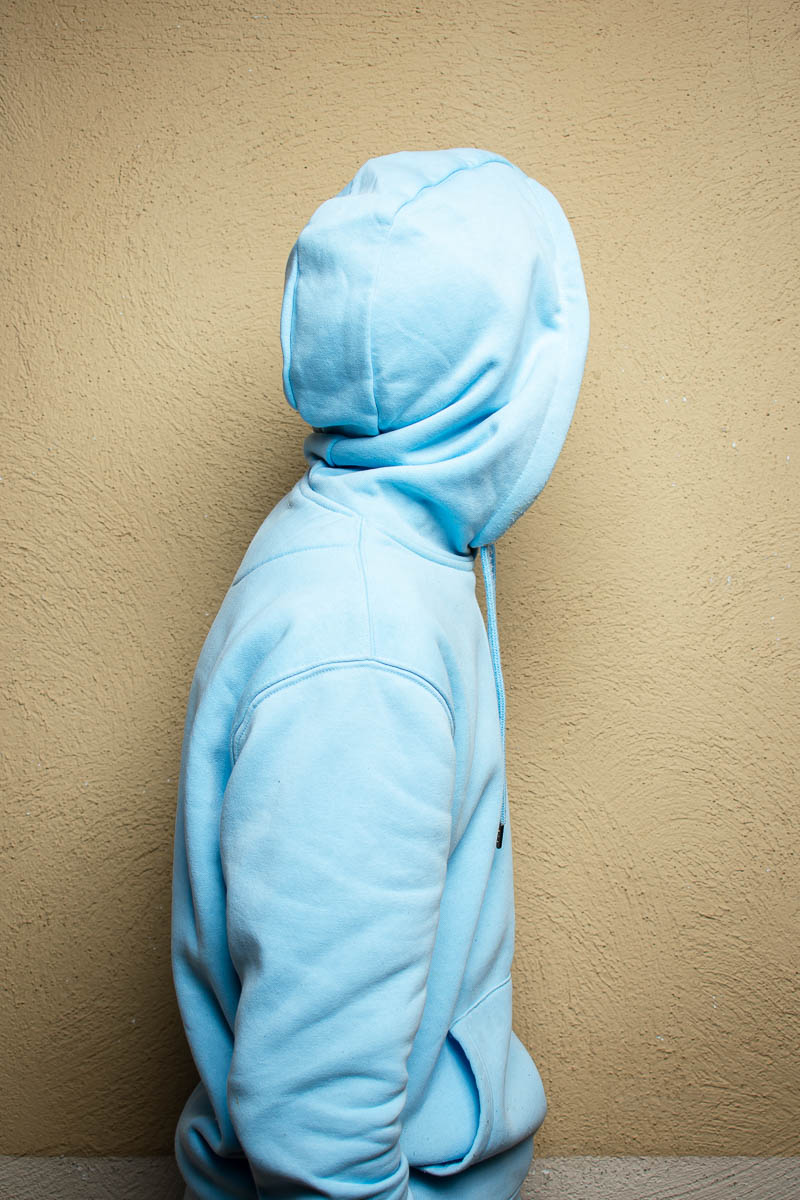 Portrait of Ahmed, covered himself from the camera, and is wearing a blue jacket.