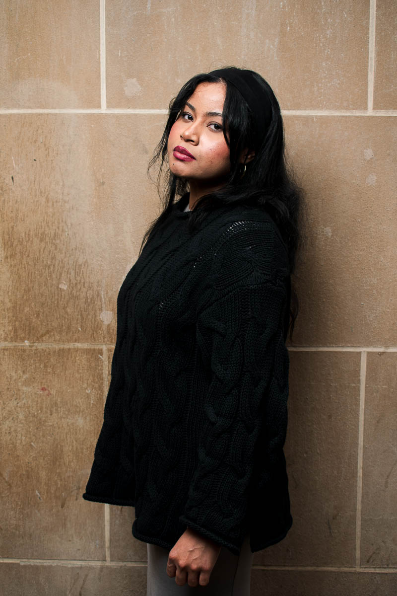 Portrait of Mayer, wearing a black long sleeve and is facing sideward while looking at the camera.