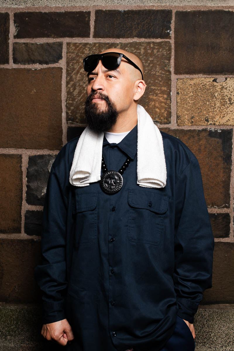 Portrait of Manuel, not facing directly to the camera and is wearing a black long sleeves and a white towel on his neck.