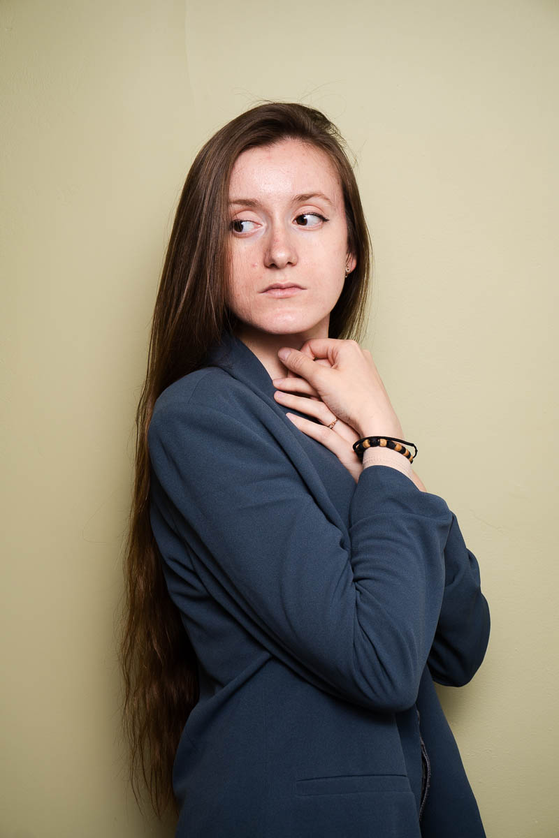 Portrait of Ulia, facing sideways and is wearing a gray long sleeves.