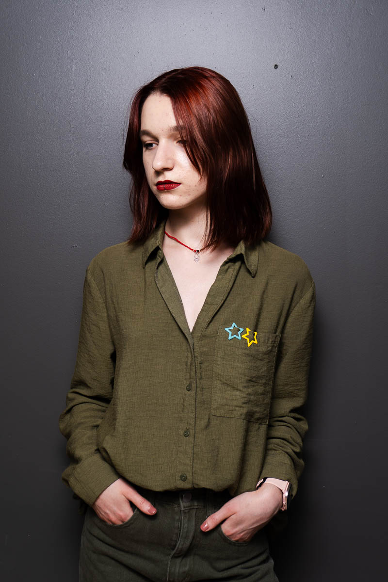 Portrait of Sofia, facing in the other side and is wearing a dark green long sleeves.