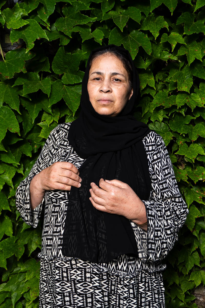 Portrait of Mari, looking intently in the camera and is wearing a black scarf.