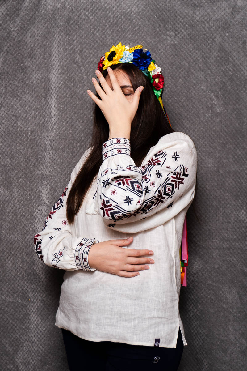 Portrait of Vesna, wearing a white sleeves with printed marks and covered her face using her hands.