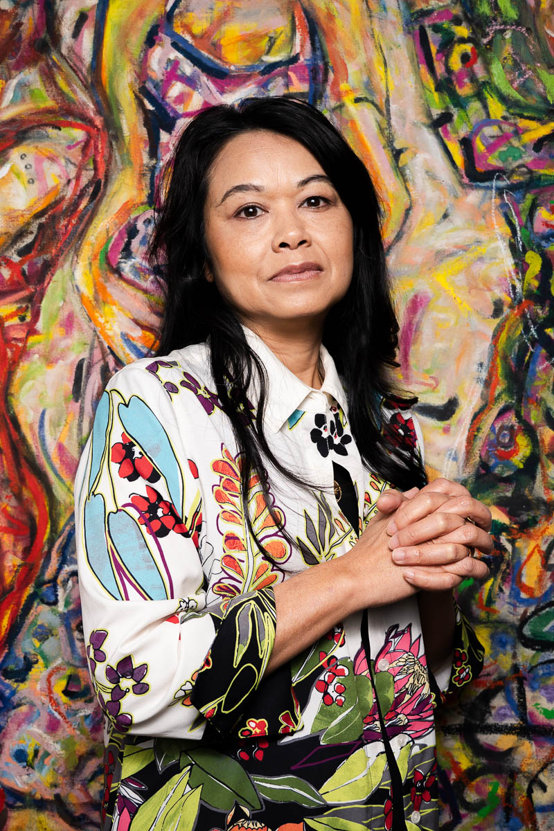 Portrait of Thavone, facing the camera and is wearing a floral long sleeves.