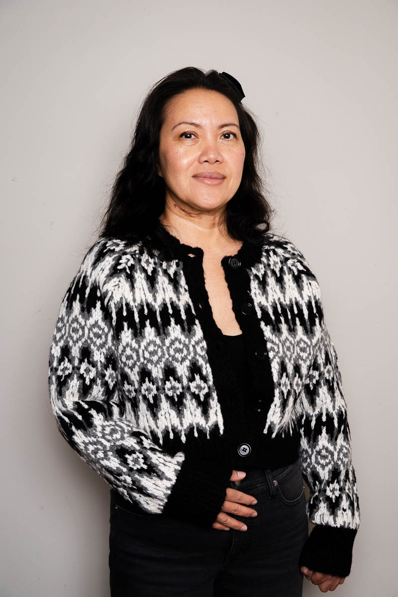 Portrait of Souksy, facing the camera and is wearing a black printed long sleeves.